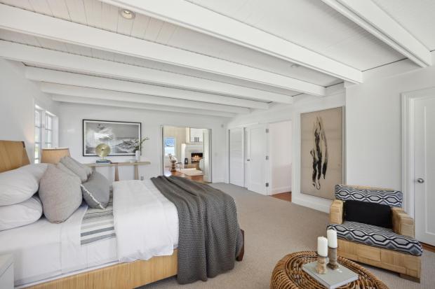 Exposed beam, A-frame bedroom in white.