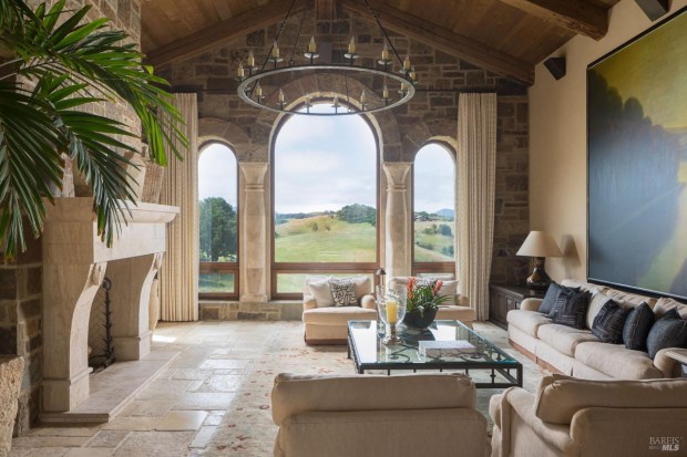 Living room with rounded windows and a chandelier.