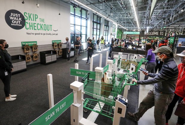 Customers using cashierless technology to checkout with an app or credit card at the first Amazon Fresh in Washington, on opening day, Thursday, June 17, 2021 in Bellevue, Washington. The store also has cashiers. (Ken Lambert/Seattle Times/TNS)