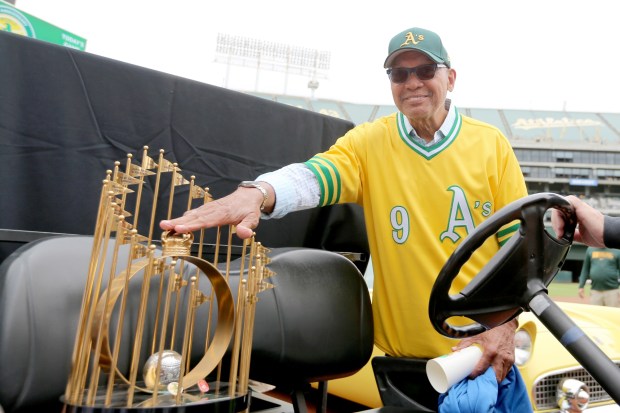 OAKLAND, CALIFORNIA - MAY 31: Former Oakland Athletics player and member of the 1972 World Series Championship team, Reggie Jackson, throws a kiss and pats their 1972 World Series Championship trophy before a MLB game between the Boston Red Sox and there A's at the Coliseum in Oakland, Calif., on Saturday, June 4, 2022. Jackson and teammates from the 1972 World Series Championship were honored during a special ceremony marking their 50th anniversary. (Ray Chavez/Bay Area News Group)