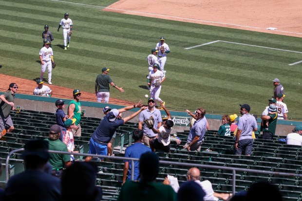 Oakland Athletics' Zack Gelof (20) throws a baseball to fans at the end of the seventh inning of their MLB game against the Kansas City Royals at the Coliseum in Oakland, Calif., on Wednesday, Aug. 23, 2023. (Ray Chavez/Bay Area News Group)