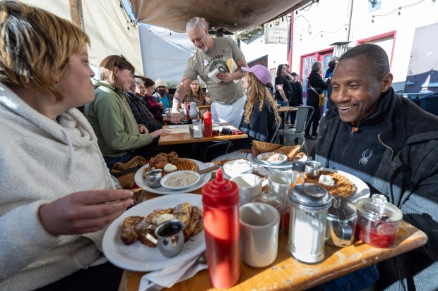 Angel Brown and Odell Stanifer enjoy a meal at the Homemade Cafe on the restaurant's final day of business in Berkeley, Calif., Monday, Jan. 1, 2024. The owner, Collin Doran serving an adjacent table, is closing after 45 years of business. (Karl Mondon/Bay Area News Group)