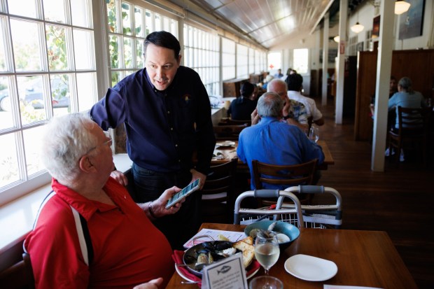 On the last day of service at The Fish Market in Palo Alto, Calif., Henry Hiatt, the general manager of the restaurant, talks with long time customer, Terry Bohn, 73, on Wednesday, Sept. 13, 2023. After 47 years, the seafood restaurant chain is closing two Northern California locations in Palo Alto and San Mateo. Today is the last day of the Palo Alto location. The last day of the San Mateo location is Sept. 20. (Dai Sugano/Bay Area News Group)