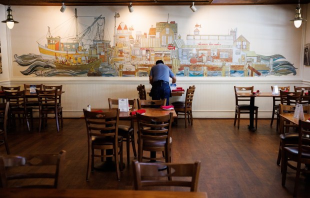 On the last day of service at The Fish Market in Palo Alto, Calif., Juan Gonzalez, who has worked in the restaurant chain since 1979, cleans a table on Wednesday, Sept. 13, 2023. After 47 years, the seafood restaurant chain is closing two Northern California locations in Palo Alto and San Mateo. Today is the last day of the Palo Alto location. The last day of the San Mateo location is Sept. 20. (Dai Sugano/Bay Area News Group)