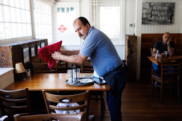 On the last day of service at The Fish Market in Palo Alto, Calif., Juan Gonzalez, who has worked in the restaurant chain since 1979, cleans a table on Wednesday, Sept. 13, 2023. After 47 years, the seafood restaurant chain is closing two Northern California locations in Palo Alto and San Mateo. Today is the last day of the Palo Alto location. The last day of the San Mateo location is Sept. 20. (Dai Sugano/Bay Area News Group)