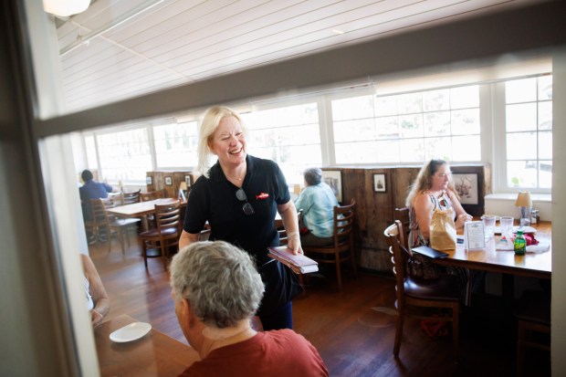 On the last day of service at The Fish Market in Palo Alto, Calif., Lyla Phelps, who has worked in the restaurant since 1980, smiles at customers on Wednesday, Sept. 13, 2023. After 47 years, the seafood restaurant chain is closing two Northern California locations in Palo Alto and San Mateo. Today is the last day of the Palo Alto location. The last day of the San Mateo location is Sept. 20. (Dai Sugano/Bay Area News Group)