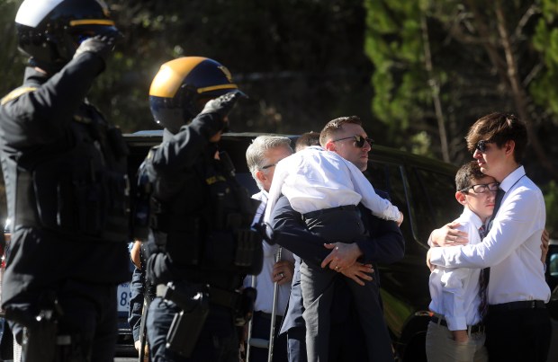 Family members embrace as law enforcement officers escort the body of Alameda County Sheriff Deputy Aubrey Phillips though the grounds of Oakmont Memorial Park & Mortuary on Feb. 15, in Lafayette. Phillips died after suffering a medical emergency while carrying out a traffic stop Saturday morning in the city of Dublin. (Aric Crabb/Staff Photographer)