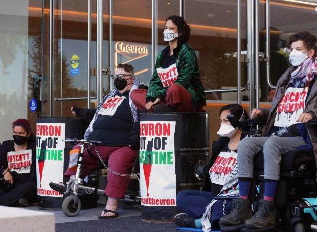 A group of pro-Palestine protesters block an entrance to Chevron offices on Wednesday, May 29, 2024, in San Ramon, Calif. Over 50 protesters gathered at the San Ramon office park to disrupt Chevron's annual shareholder meeting. (Aric Crabb/Bay Area News Group)