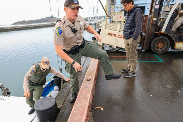 California Department of Fish and Wildlife (CDFW) Wildlife wardens Promes, center, and Lt. Ober make inspections on fishing boats during the first official day of commercial Dungeness crab fishing season at Pillar Point Harbor in Half Moon Bay, Calif., on Thursday, Jan. 18, 2024. (Ray Chavez/Bay Area News Group)