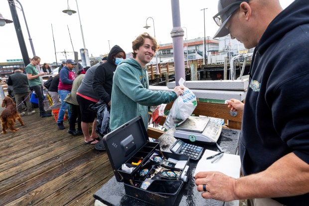 Jake Karp lined up first to buy fresh Dungeness crab from Matt Juanes, the captain of the Plumeria, after it returned to the dock at Fisherman's Wharf, Thursday, Jan. 18, 2024. The crustaceans were among the first catch coming in to port after a two-month long crab season delay. (Karl Mondon/Bay Area News Group)