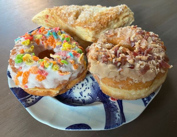 A bacon-maple doughnut, breakfast-cereal doughnut and apple turnover from Dream Fluff Donuts in Berkeley. (John Metcalfe/Bay Area News Group)