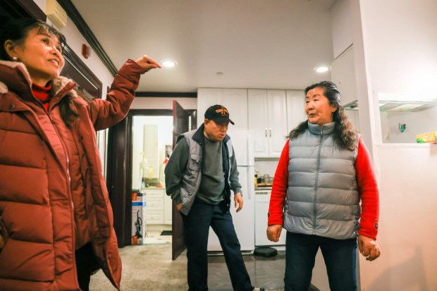 Community Liaison for Senior Coastsiders, Kiki Wolfeld, left, talks with retired farmworkers and mass shooting survivors, Jinsheng Liu and his wife Yingze Wang at their new home in Half Moon Bay on Saturday, Jan. 13, 2024. The couple lived at Concord Farms where a coworker killed three workers after fatally shooting four and wounding another at California Terra Garden Farms. (Ray Chavez/Bay Area News Group)