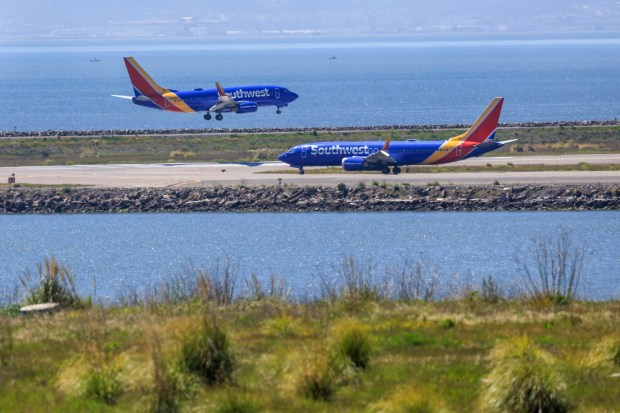 While one Southwest airplane arrives, another one gets ready to depart from the San Francisco Bay Oakland International Airport on Thursday, April 11, 2024. The San Francisco Bay Oakland International Airport is expected to be busy throughout the Memorial Day holiday travel weekend. More than 130,000 passengers are expected at the airport during the long weekend. (Ray Chavez/Bay Area News Group)