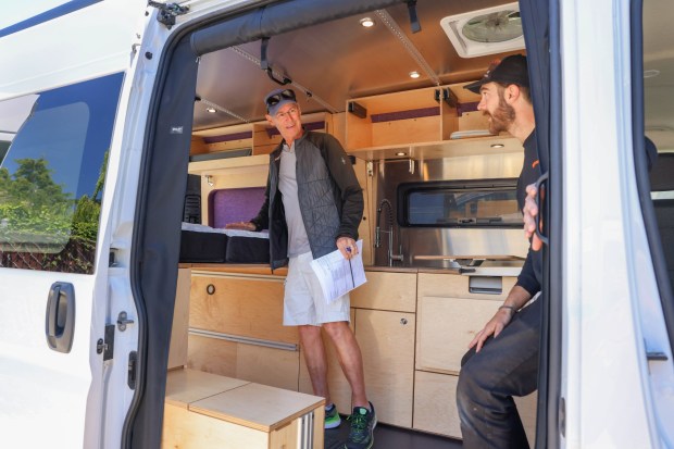 Customer David Rowland, left, of Walnut Creek, checks his soon-to-own Glampervan as Andrew Stenken, owner of Glampervan Global LLC, talks with him at his lot in Oakland, Calif., on Friday, May 17, 2023. (Ray Chavez/Bay Area News Group)