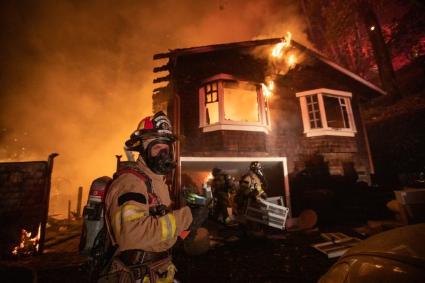 Firefighters remove items from a garage after a wildland fire ignited a home along Tucker Road in Calistoga, Calif., on Friday, Oct. 2, 2020. On Thursday, March 14, 2024, California Insurance Commissioner Ricardo Lara unveiled a proposal for letting those insurers use computer models of possible future catastrophes to justify rate increases. The plan is part of a yearlong effort to overhaul regulations and ease the insurance market crisis in the wildfire-stricken state. (Anda Chu/Bay Area News Group)