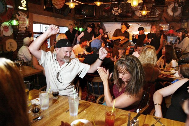 Ray Chavez/staff 8/11/06 TribuneGlenn Onan, center left, and Joana Pepperer, among other customers, enjoy a few drinks and the performance by the Starboard Watch band at Quinn's Lighthouse in Oakland Thursday night.