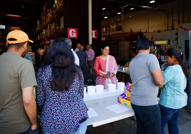 Syamala Raghuram, co-founder and president of Shastha Foods, center, helps sell mangoes at Shastha Foods in San Jose, Calif., on Friday, May 10, 2024. (Shae Hammond/Bay Area News Group)