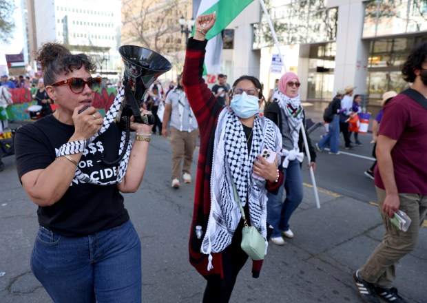 Pro-Palestinian protesters march down 14th Street as they head to a May Day rally at City Hall in downtown Oakland, Calif., on Wednesday, May 1, 2024. Multiple protests took place throughout the Bay Area as part of May Day action in support of workers and Palestinian people. (Jane Tyska/Bay Area News Group)