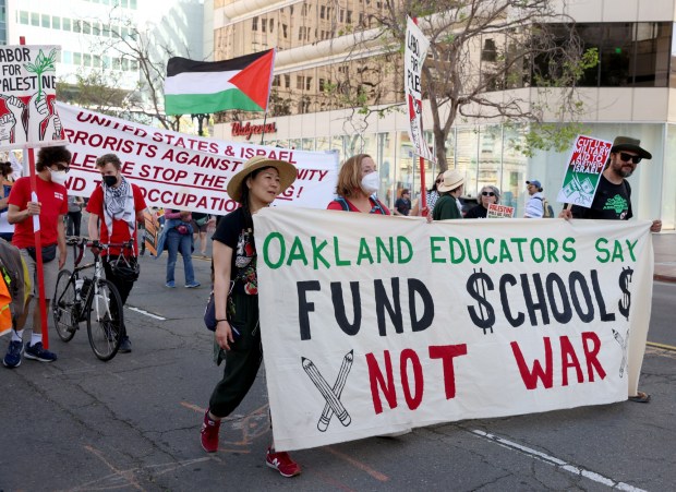 Pro-Palestinian protesters march down Broadway as they head to a May Day rally at City Hall in downtown Oakland, Calif., on Wednesday, May 1, 2024. Multiple protests took place throughout the Bay Area as part of May Day action in support of workers and Palestinian people. (Jane Tyska/Bay Area News Group)