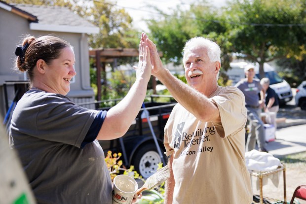 SAN JOSE, CALIFORNIA - September 20: Lowe's employee Kimberly Montalvo, left, high-fives the homeowner John Migeulgorry, 79, a Vietnam War veteran, on Sept. 20, 2022, in San Jose, Calif. (Dai Sugano/Bay Area News Group)