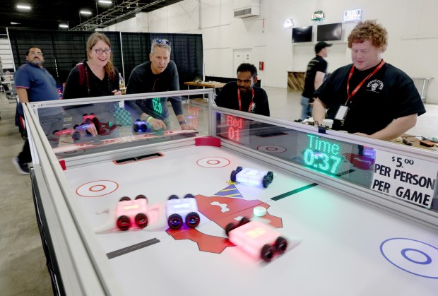 Sharon and Al Flor, of Oakland, play a robotic hockey game during the RoboGames 2023 competition at the Alameda County Fairgrounds in Pleasanton, Calif., on Thursday, April 6, 2023. To the right is referee Daniel Baron. Both local and international participants competed in over 40 events at the 16th annual world championship. (Jane Tyska/Bay Area News Group)