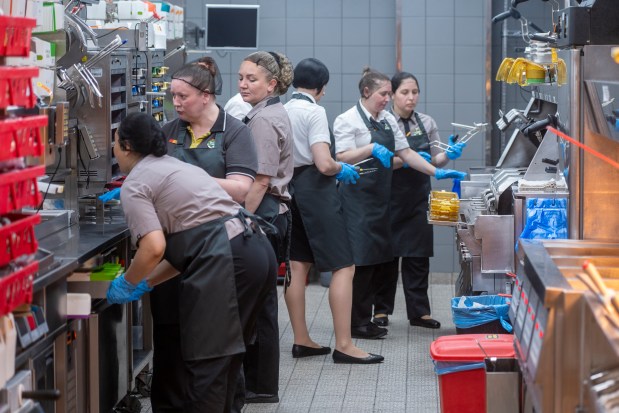 Kitchen staff members work at a newly opened fast food restaurant in a former McDonald's outlet in Bolshaya Bronnaya Street in Moscow, Russia, Sunday, June 12, 2022. The first of former McDonald's restaurants is reopened with new branding in Moscow. The corporation sold its branches in Russia to one of its local licensees after Russia sent tens of thousands of troops into Ukraine. (AP Photo/Dmitry Serebryakov)