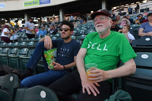 A's fan Carter White, of Richmond, wears his SELL shirt with sitting with friend Laith Adawiya, of Davis, while watching the River Cats play the El Paso Chihuahuas during a game at Sutter Health Park in Sacramento, Calif., on Thursday, April 11, 2024. (Jose Carlos Fajardo/Bay Area News Group)