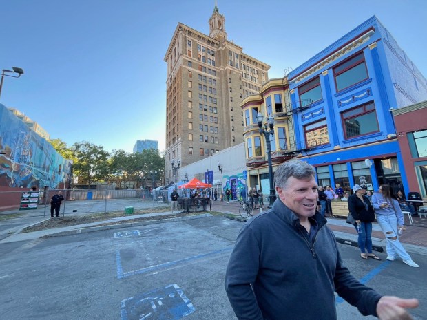 Gary Dillabough, a principal executive with real estate firm Urban Community, attends a block party in Fountain Alley. The Bank of Italy historic tower at 12 South First Street in downtown San Jose is in the background.(George Avalos/Bay Area News Group)