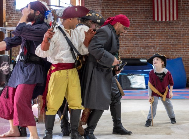 A 7-year-old Make-a-Wish child named James, visiting the Davenriche European Martial Arts School in San Jose, Calif., rounds up a corral of pirates played by the school's students, Friday March, 24, 2023. (Karl Mondon/Bay Area News Group)