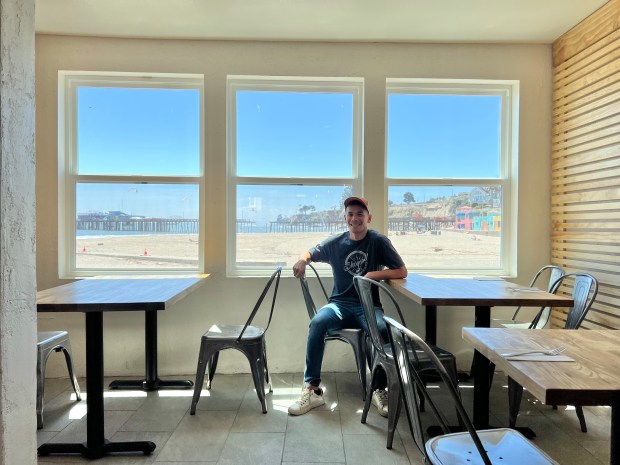 My Thai Beach owner Dominick King sits in front of the wall in his restaurant that had to be torn out and repaired after January's storms. The restaurant reopened for the first time in months late last week. (PK Hattis - Santa Cruz Sentinel)