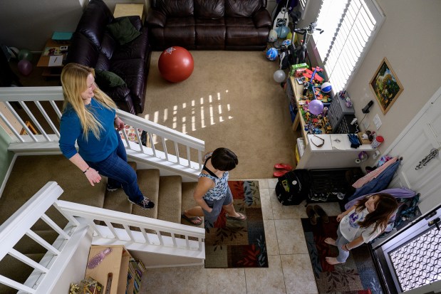 Rachel Wineman walks with children Kestrel, 13, middle, and Rosie, 11, to head outside to make chalk drawings on the driveway in Murrieta. (Gina Ferazzi/Los Angeles Times/TNS)